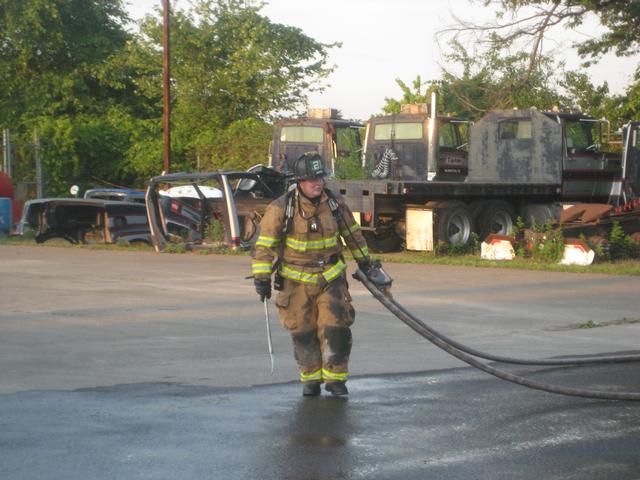 Firefighter Tim McDonnell pulling a handline out of the scene.